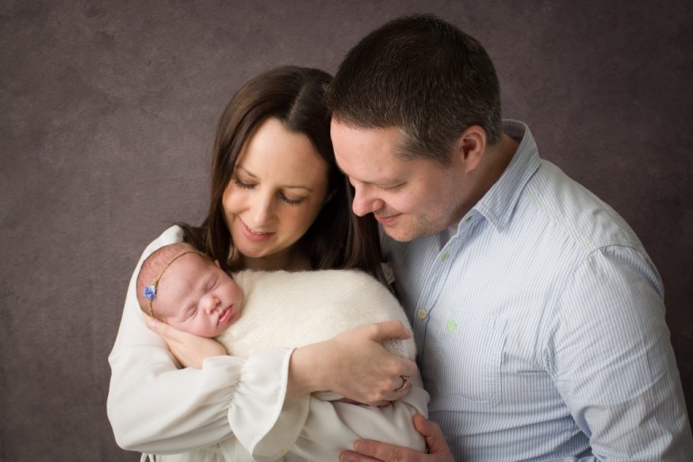 Mother and father looking fondly at their newborn baby